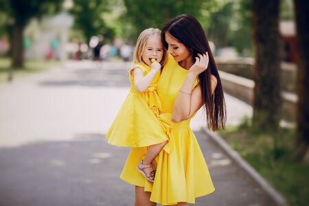 beautiful young mother with  small daughter walks through cityの写真素材