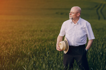 an elderly man walks on the fieldの写真素材