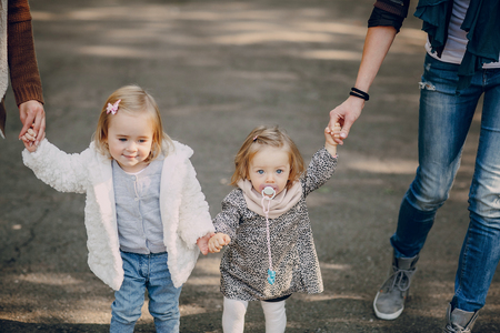 great trendy young mothers walking in the park with his daughters in beautiful clothingの写真素材