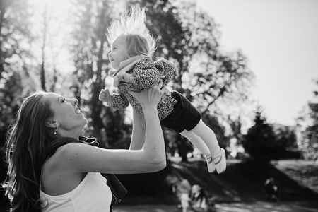 great trendy young mothers walking in the park with his daughters in beautiful clothingの写真素材