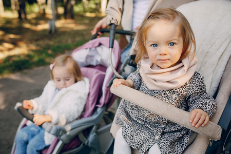 young mother walking with her baby and carries it in a beautiful pram