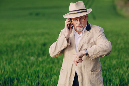 an elderly man walks pool and talking on the phoneの写真素材