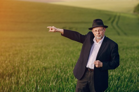 an elderly man walks on the fieldの写真素材