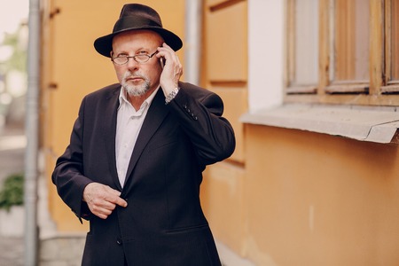 the old man uses the phone in the streetの写真素材