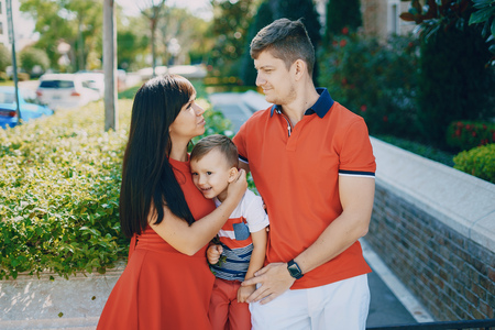 beautiful family in red walking down the street and the Parkの写真素材