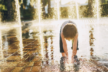 Joyful boy play water at the parkの写真素材
