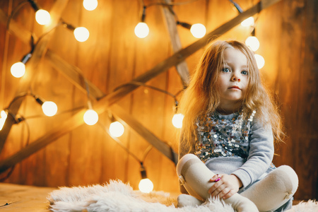 little blonde baby girl sitting on the floorの写真素材