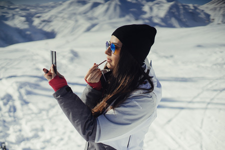 girl with ski outfit putting on makeupの写真素材
