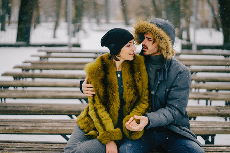 happy couple walking through the park on a sunny winter dayの写真素材