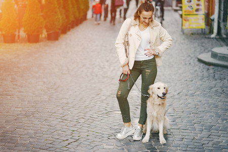 girl walking dog in the cityの写真素材