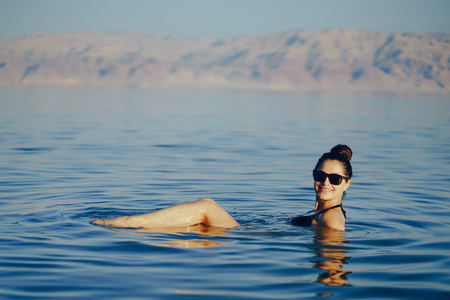 brunette girl swimming in the dead seaの写真素材