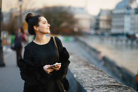 woman using her cell phone while walking through Parisの写真素材