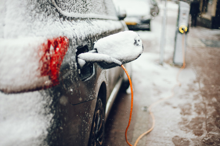 Charging an electric car with the power cable supplyの写真素材
