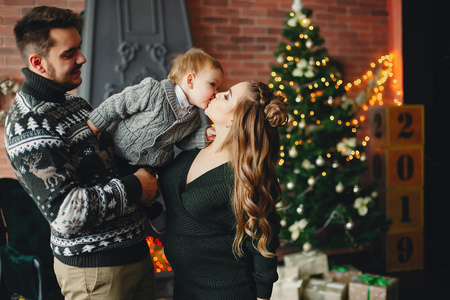 Cute family sitting near Christmas treeの写真素材