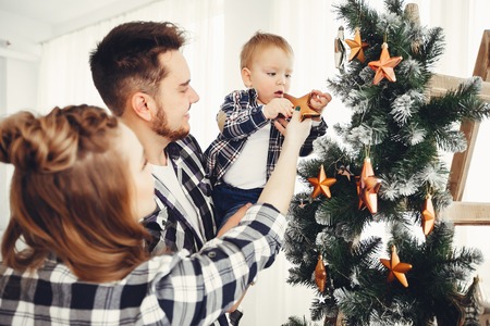Cute family standing near Christmas treeの写真素材