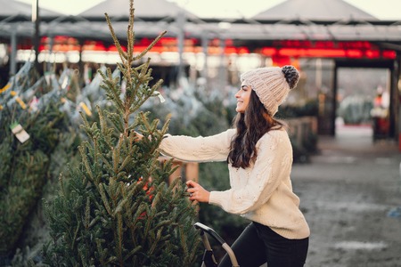Cute brunette in a white sweater with Christmas treeの写真素材