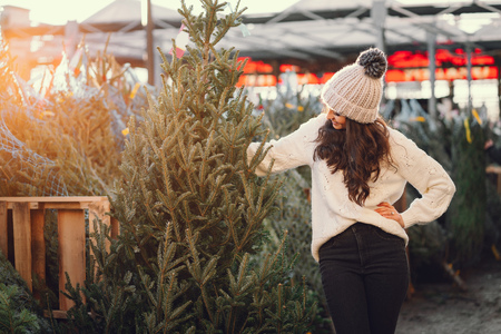 Cute brunette in a white sweater with Christmas treeの写真素材