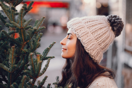 Cute brunette in a white sweater with Christmas treeの写真素材
