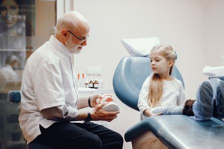 Cute little girl sitting in the dentists officeの写真素材
