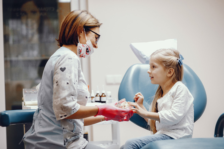 Cute little girl sitting in the dentists officeの写真素材