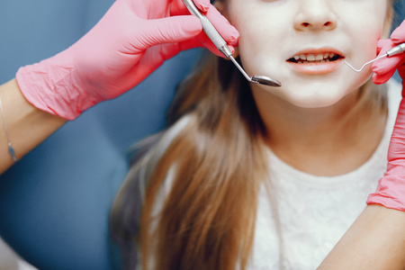 Cute little girl sitting in the dentists officeの写真素材