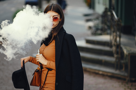 stylish girl smoking an e-cigaretteの写真素材