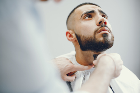 The man cuts his beard in the barbershopの写真素材