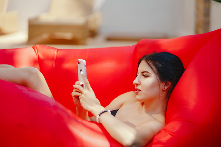 brunette girl using and talking on her phone in the poolの写真素材
