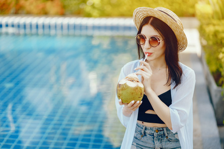 girl drinking fresh juice from a coconutの写真素材