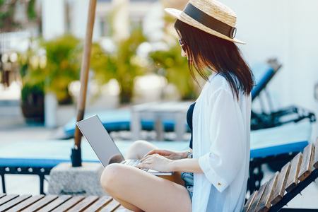 brunette girl working by the poolの写真素材