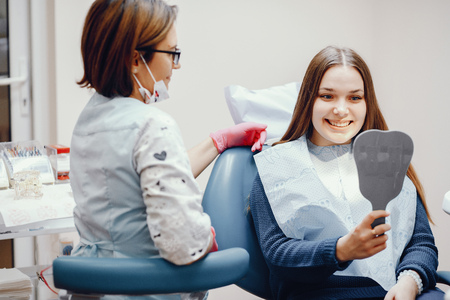 Beautiful girl sitting in the dentists officeの写真素材