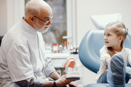 Cute little girl sitting in the dentists officeの写真素材