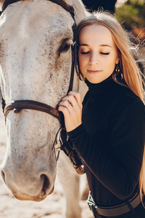 Elegants girl with a horse in a ranchの写真素材