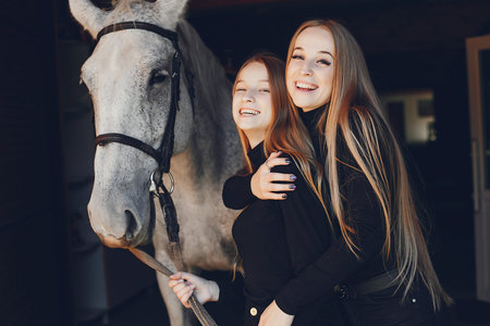 Elegant girls with a horse in a ranchの写真素材