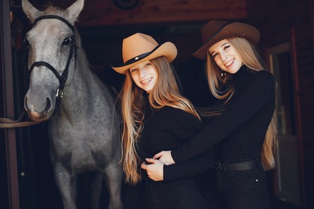 Elegant girls with a horse in a ranchの写真素材