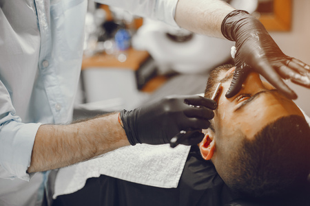 The man cuts his beard in the barbershopの写真素材