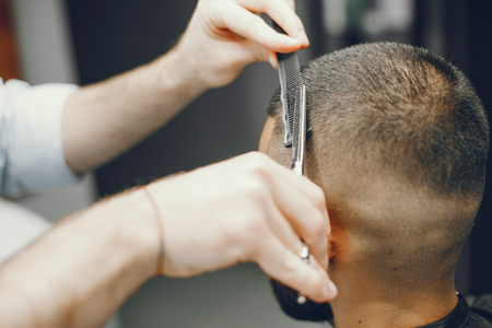 A man cuts hair in a barbershopの写真素材