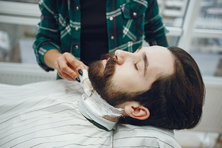 Stylish man sitting in a barbershopの写真素材