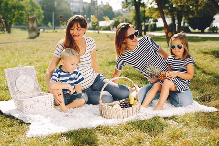 Mothers with kids playing in a summer parkの写真素材