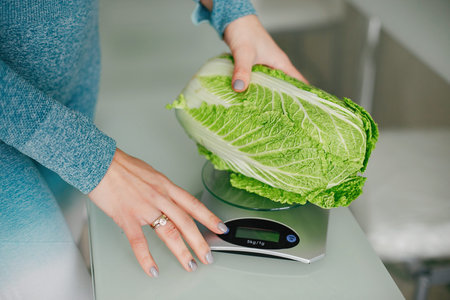 Sports girl in a kitchen with vegetables