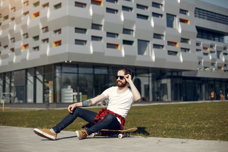Stylish guy with skate in a summer cityの写真素材