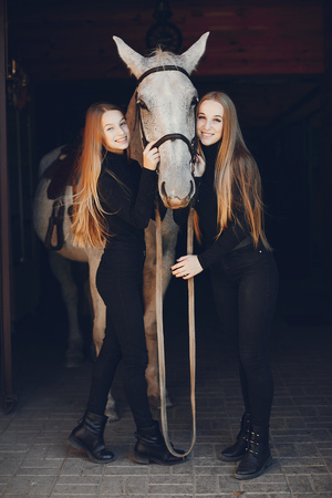 Elegant girls with a horse in a ranchの写真素材