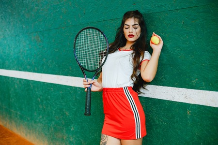Beautiful and stylish girl on the tennis courtの写真素材