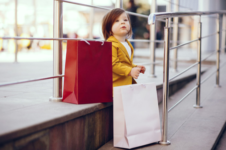 Cute little girl with shopping bag in a cityの写真素材