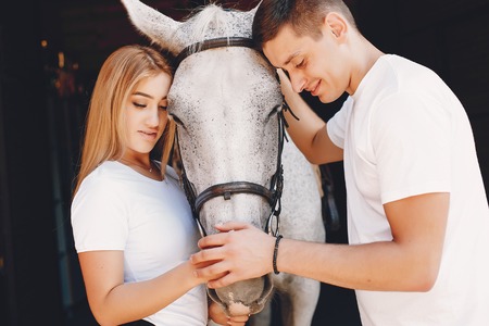 Beautiful couple spend time with a horsesの写真素材
