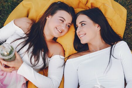 Two pretty girls in a summer parkの写真素材