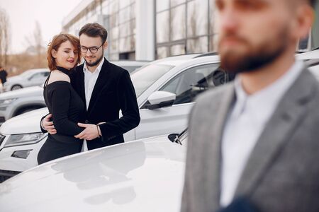 Stylish and elegant couple in a car salonの写真素材