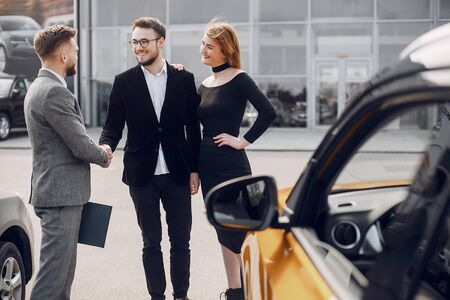 Stylish and elegant couple in a car salonの写真素材