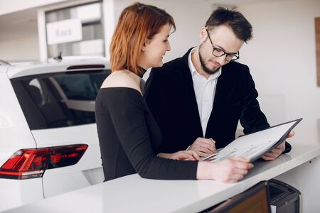 Stylish and elegant couple in a car salonの写真素材