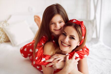 Cute mother and daughter at home in a pajamasの写真素材